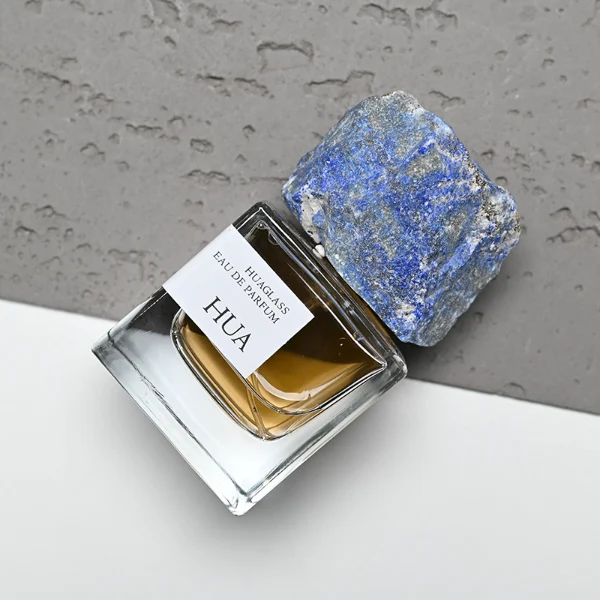 HUA0124 perfume bottle, square clear glass with outer label, irregular crystal stone cap with natural raw texture, contemporary decorative design, available in 30 ml, 50 ml, and 100 ml