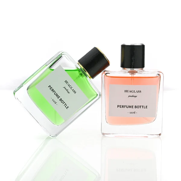 HUA0128 perfume bottle, square clear glass body with 50 ml or 100 ml liquid, cylindrical plastic cap, outer label with printed logo, modern minimalist design, ideal for gifting and daily use.
