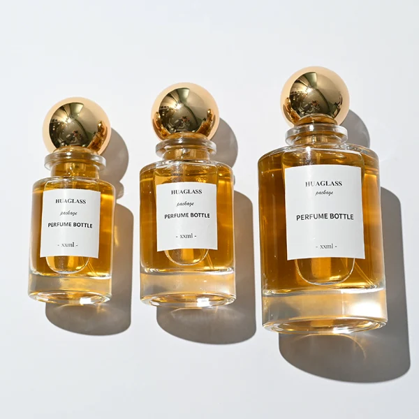 HUA0130 perfume bottle, cylindrical clear glass body with 30 ml, 50 ml, or 100 ml liquid, spherical plastic cap, outer label with printed logo, modern elegant design, ideal for gifting and daily use.