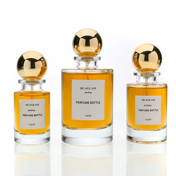 HUA0130 perfume bottle, cylindrical clear glass body with 30 ml, 50 ml, or 100 ml liquid, spherical plastic cap, outer label with printed logo, modern elegant design, ideal for gifting and daily use.