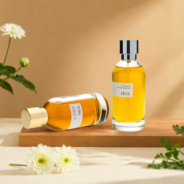 HUA0131 perfume bottle, cylindrical clear glass body with 100 ml liquid, stacked ring-style cylindrical Zamac cap, outer label with printed logo, modern elegant design, ideal for gifting and daily use.
