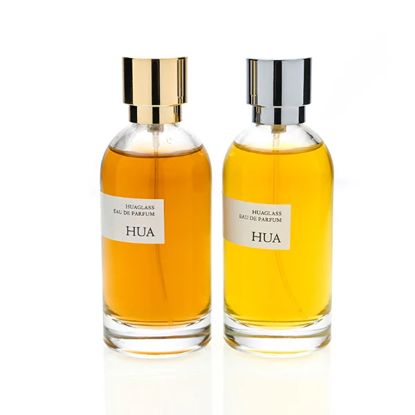 HUA0131 perfume bottle, cylindrical clear glass body with 100 ml liquid, stacked ring-style cylindrical Zamac cap, outer label with printed logo, modern elegant design, ideal for gifting and daily use.