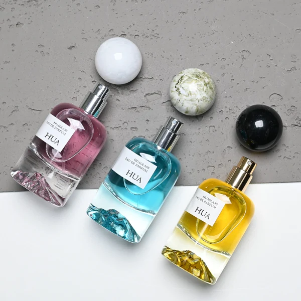 HUA0132 perfume bottle, cylindrical clear glass body with 30 ml, 50 ml, or 100 ml liquid, spherical plastic cap in milky white or black with marble texture, outer label with printed logo, modern minimalist design, ideal for gifting and daily use.