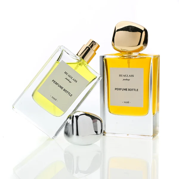 HUA0133 perfume bottle, rectangular clear glass body with 30 ml or 50 ml liquid, irregular-shaped plastic cap, outer label with printed logo, modern elegant design, ideal for gifting and daily use.