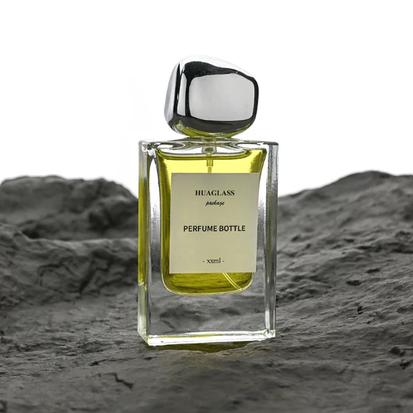 HUA0133 perfume bottle, rectangular clear glass body with 30 ml or 50 ml liquid, irregular-shaped plastic cap, outer label with printed logo, modern elegant design, ideal for gifting and daily use.