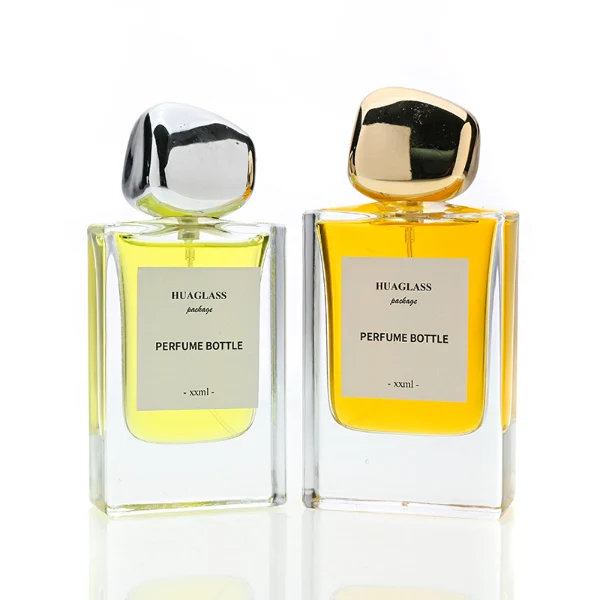 HUA0133 perfume bottle, rectangular clear glass body with 30 ml or 50 ml liquid, irregular-shaped plastic cap, outer label with printed logo, modern elegant design, ideal for gifting and daily use.