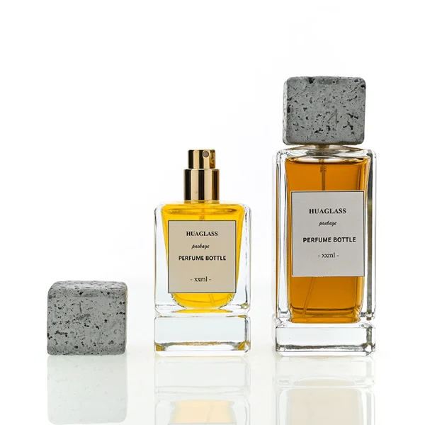 HUA0136 perfume bottle, rectangular clear glass body with 30 ml, 50 ml, or 100 ml liquid, square cement cap, outer label with printed logo, modern minimalist design, ideal for gifting and daily use.