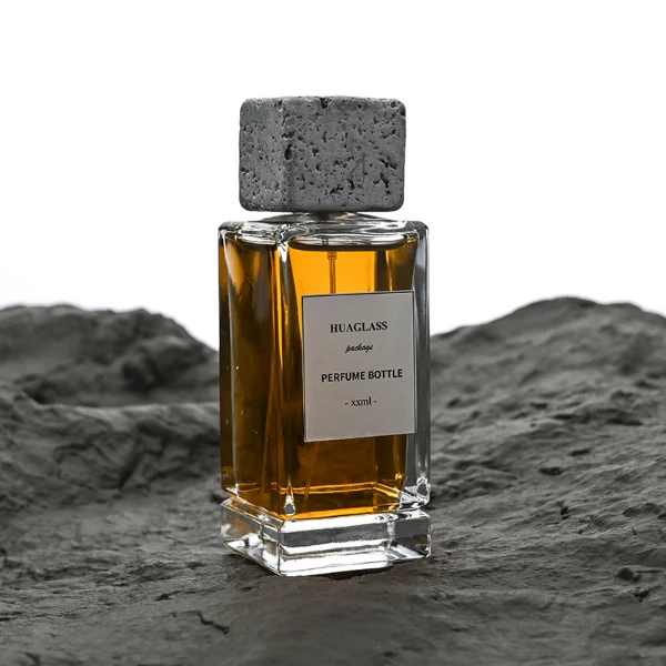 HUA0136 perfume bottle, rectangular clear glass body with 30 ml, 50 ml, or 100 ml liquid, square cement cap, outer label with printed logo, modern minimalist design, ideal for gifting and daily use.