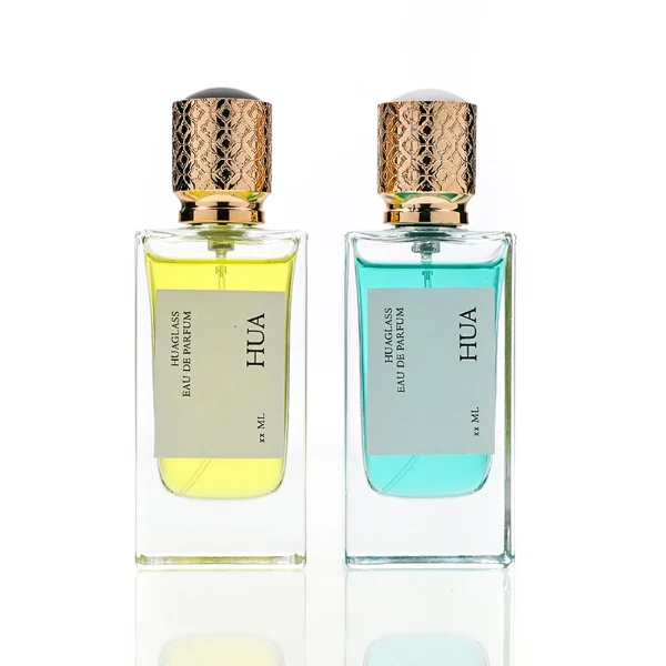 HUA0137 perfume bottle, square customizable glass body with 30 ml or 50 ml liquid, spherical plastic cap with gold metallic neck, outer label with printed logo, modern elegant design, ideal for gifting and daily use.