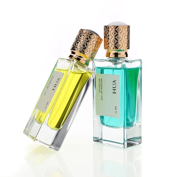 HUA0137 perfume bottle, square customizable glass body with 30 ml or 50 ml liquid, spherical plastic cap with gold metallic neck, outer label with printed logo, modern elegant design, ideal for gifting and daily use.