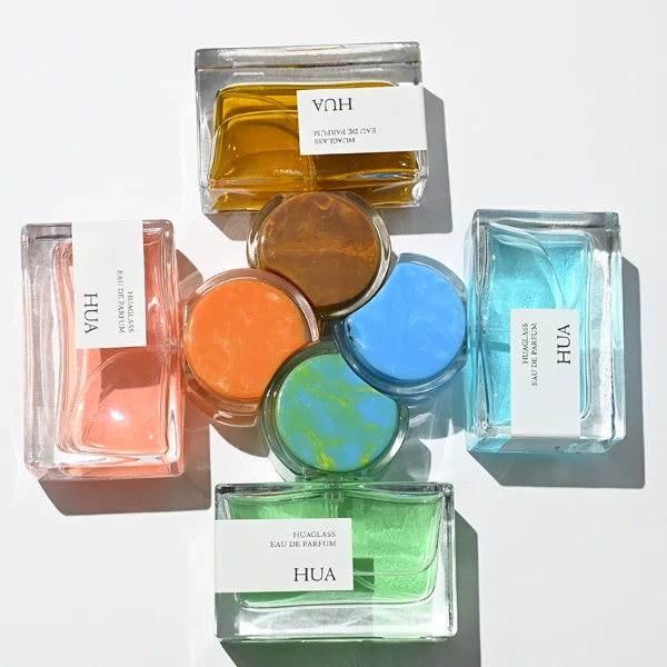 HUA0139 perfume bottle, rectangular clear glass body with 30 ml, 50 ml, or 100 ml liquid, crescent-shaped resin cap with solid marble texture encased in transparent ring, outer label with printed logo, modern elegant design, ideal for gifting and daily use.