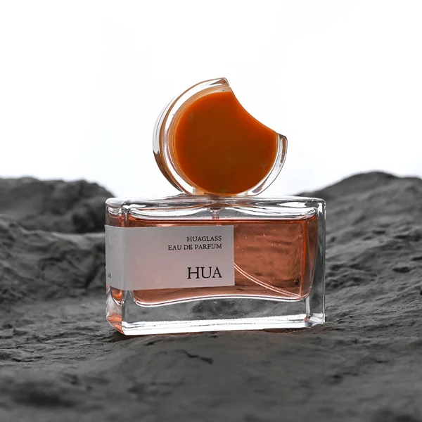 HUA0139 perfume bottle, rectangular clear glass body with 30 ml, 50 ml, or 100 ml liquid, crescent-shaped resin cap with solid marble texture encased in transparent ring, outer label with printed logo, modern elegant design, ideal for gifting and daily use.