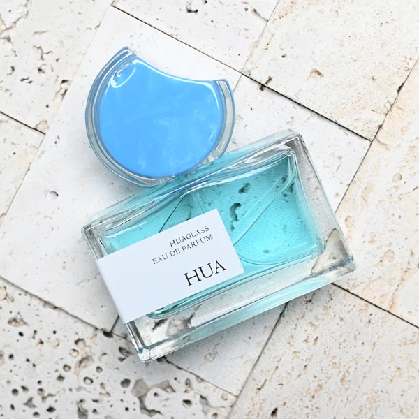 HUA0139 perfume bottle, rectangular clear glass body with 30 ml, 50 ml, or 100 ml liquid, crescent-shaped resin cap with solid marble texture encased in transparent ring, outer label with printed logo, modern elegant design, ideal for gifting and daily use.