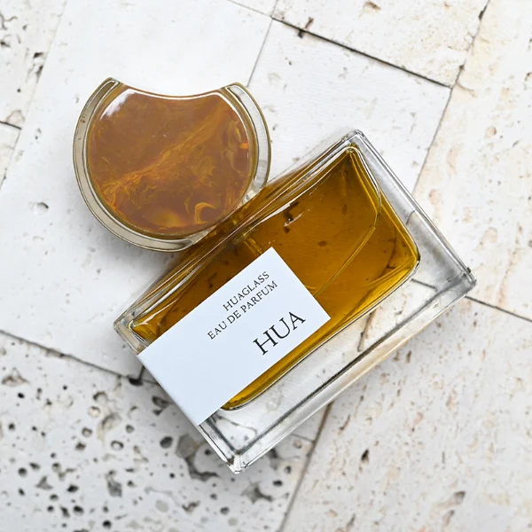 HUA0139 perfume bottle, rectangular clear glass body with 30 ml, 50 ml, or 100 ml liquid, crescent-shaped resin cap with solid marble texture encased in transparent ring, outer label with printed logo, modern elegant design, ideal for gifting and daily use.
