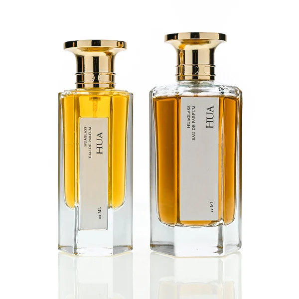 HUA0140 perfume bottle, hexagonal clear glass body with 50 ml or 100 ml liquid, Zamac cap with conical funnel top and cylindrical base with ring detailing, outer label with printed logo, modern elegant design, ideal for gifting and daily use.