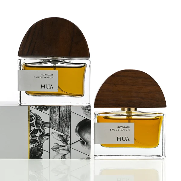 HUA0144 perfume bottle, rectangular clear glass body with 30 ml, 50 ml, or 100 ml liquid, half-circle wooden cap with gold metallic neck, outer label with printed logo, modern elegant design, ideal for gifting and daily use.