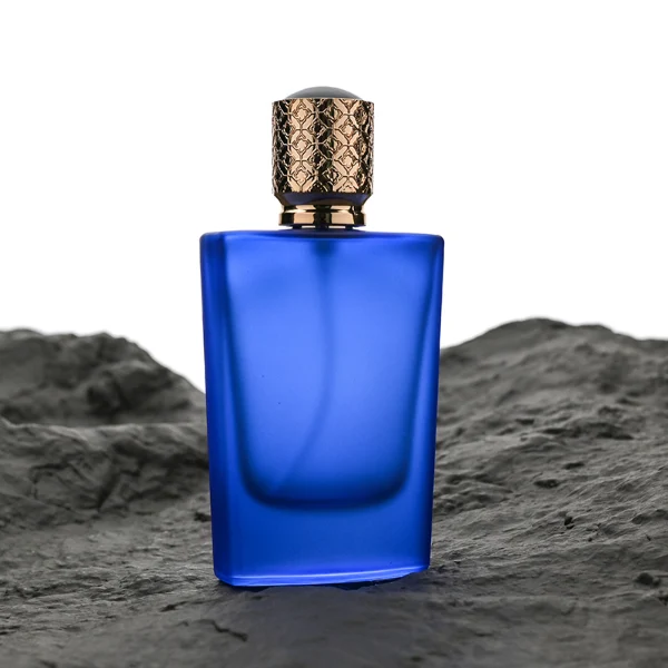 HUA0146 perfume bottle, rectangular frosted opaque glass body with 30 ml or 50 ml liquid, cylindrical plastic cap with gold carved patterns, outer label with printed logo, modern elegant design, ideal for gifting and daily use.