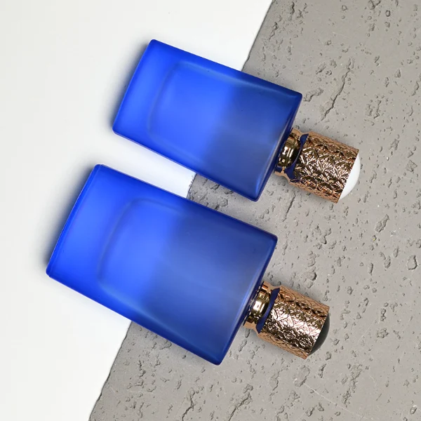 HUA0146 perfume bottle, rectangular frosted opaque glass body with 30 ml or 50 ml liquid, cylindrical plastic cap with gold carved patterns, outer label with printed logo, modern elegant design, ideal for gifting and daily use.