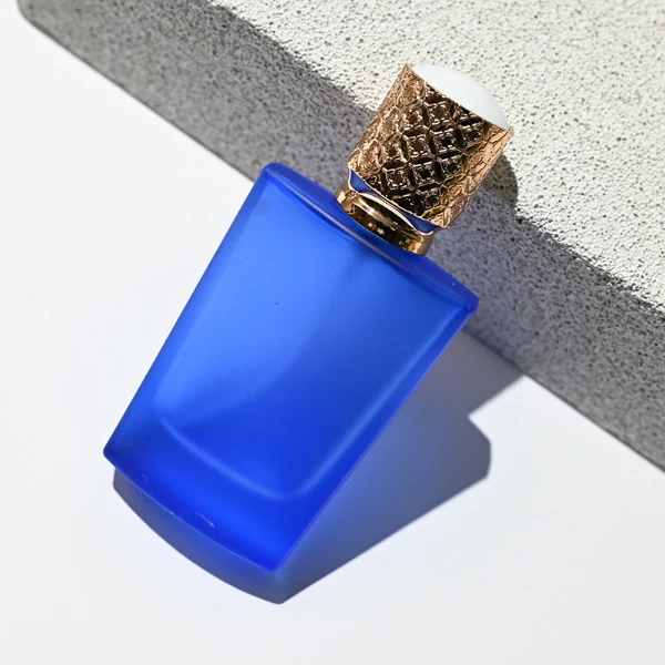 HUA0146 perfume bottle, rectangular frosted opaque glass body with 30 ml or 50 ml liquid, cylindrical plastic cap with gold carved patterns, outer label with printed logo, modern elegant design, ideal for gifting and daily use.