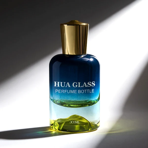 HUA0148 perfume bottle, cylindrical customizable gradient glass body with mountain-shaped base, 30 ml, 50 ml, or 100 ml liquid, irregular cylindrical cap with raised top in gold or silver, outer label with printed logo, modern elegant design, ideal for gifting and daily use.