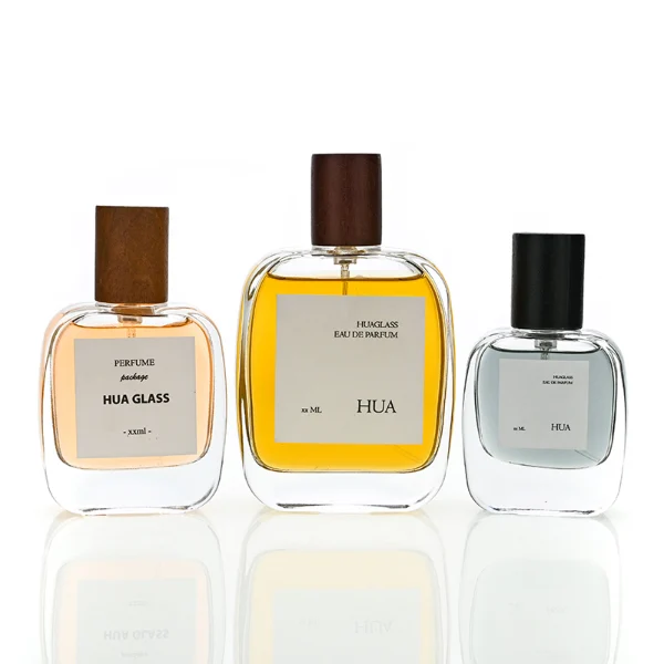 HUA0149 perfume bottle, rectangular clear glass body with 30 ml, 50 ml, or 100 ml liquid, cylindrical wooden cap, outer label with printed logo, modern elegant design, ideal for gifting and daily use.