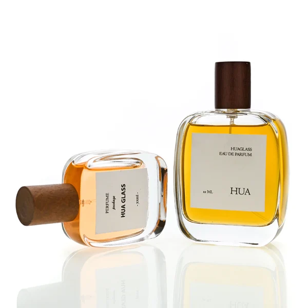 HUA0149 perfume bottle, rectangular clear glass body with 30 ml, 50 ml, or 100 ml liquid, cylindrical wooden cap, outer label with printed logo, modern elegant design, ideal for gifting and daily use.