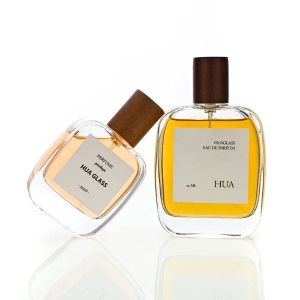 HUA0149 perfume bottle, rectangular clear glass body with 30 ml, 50 ml, or 100 ml liquid, cylindrical wooden cap, outer label with printed logo, modern elegant design, ideal for gifting and daily use.