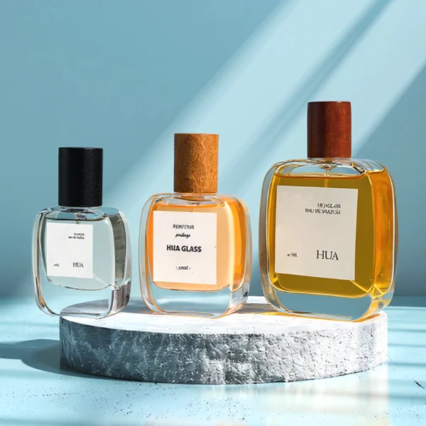 HUA0149 perfume bottle, rectangular clear glass body with 30 ml, 50 ml, or 100 ml liquid, cylindrical wooden cap, outer label with printed logo, modern elegant design, ideal for gifting and daily use.