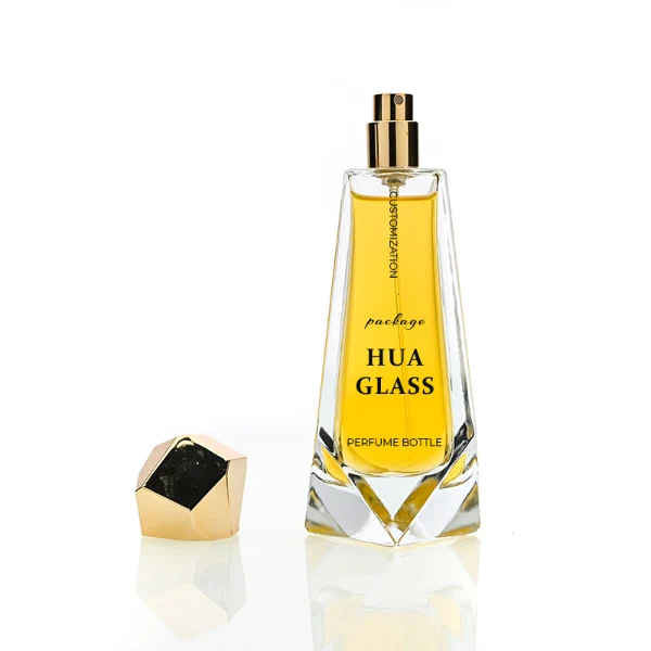 HUA0150 perfume bottle, trapezoidal faceted glass body with 100 ml liquid, irregular multi-faceted plastic cap with plastic neck, outer label with printed logo, modern luxurious design, ideal for gifting and daily use.
