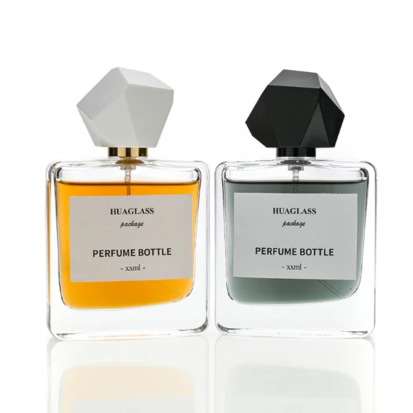 HUA0152 perfume bottle, rectangular clear glass body with 50 ml or 100 ml liquid, faceted geometric plastic cap, outer label with printed logo, modern luxurious design, ideal for gifting and daily use.