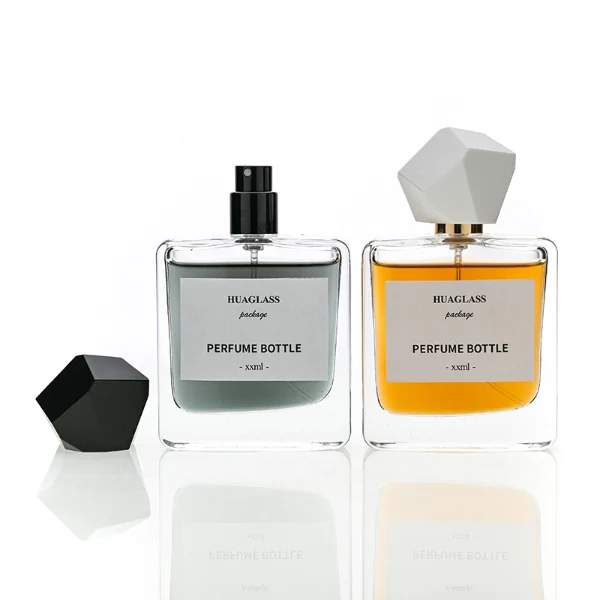 HUA0152 perfume bottle, rectangular clear glass body with 50 ml or 100 ml liquid, faceted geometric plastic cap, outer label with printed logo, modern luxurious design, ideal for gifting and daily use.
