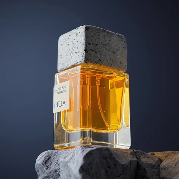 HUA0153 perfume bottle, rectangular clear glass body with 30 ml, 50 ml, or 100 ml liquid, square cement cap, outer label with printed logo, modern elegant design, ideal for gifting and daily use.