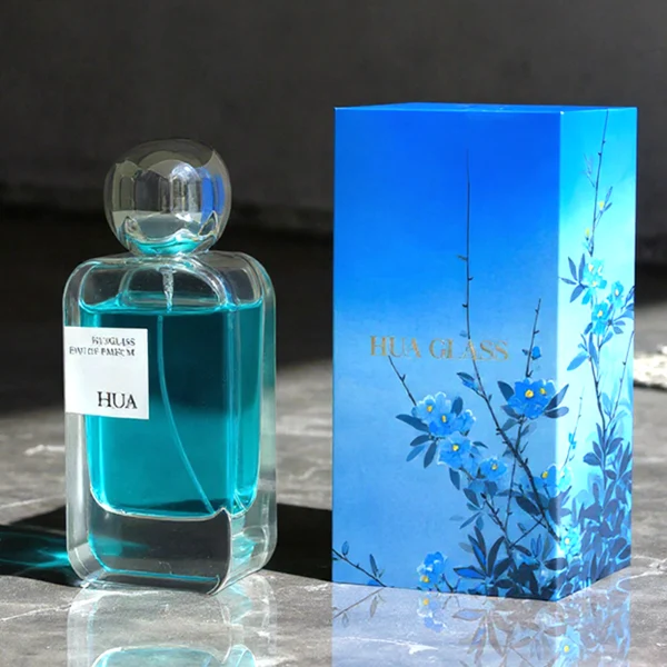 HUA0154 perfume bottle, rectangular clear glass body with 30 ml, 50 ml, or 100 ml liquid, irregular spherical plastic cap with customizable color, outer label with printed logo, modern elegant design, ideal for gifting and daily use.