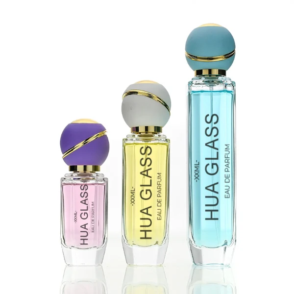 HUA0155 perfume bottle, cylindrical transparent glass body with 30 ml, 50 ml, or 100 ml liquid, spherical plastic cap with diagonal gold stripe, gold top, and gold metallic neck, outer label with printed logo, modern elegant design, ideal for gifting and daily use.