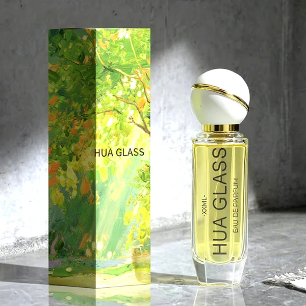 HUA0155 perfume bottle, cylindrical transparent glass body with 30 ml, 50 ml, or 100 ml liquid, spherical plastic cap with diagonal gold stripe, gold top, and gold metallic neck, outer label with printed logo, modern elegant design, ideal for gifting and daily use.