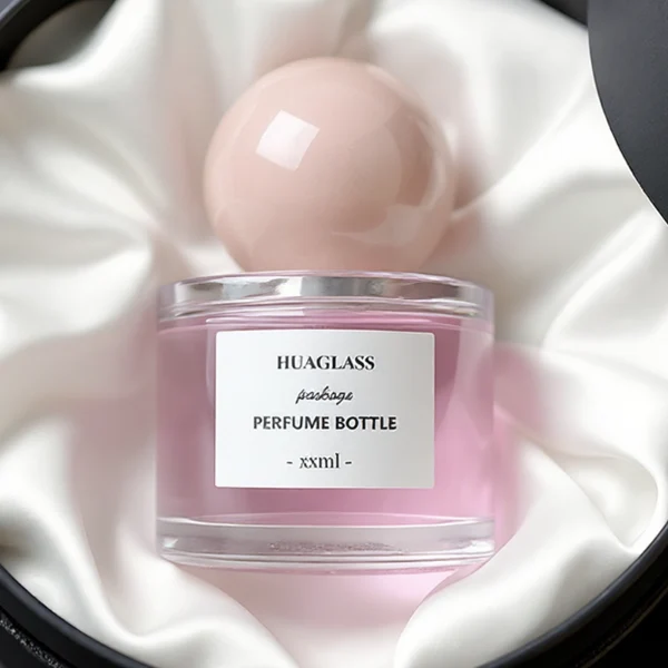 HUA0157 perfume bottle, cylindrical clear glass body with 30 ml, 50 ml, or 100 ml liquid, spherical crystal stone cap, outer label with printed logo, modern elegant design, ideal for gifting and daily use.