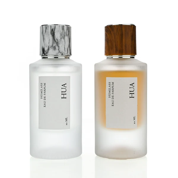 HUA0159 perfume bottle, cylindrical frosted glass body with 30 ml or 50 ml liquid, cylindrical plastic cap with silver rings at both ends, water transfer printed logo, modern elegant design, ideal for gifting and daily use.
