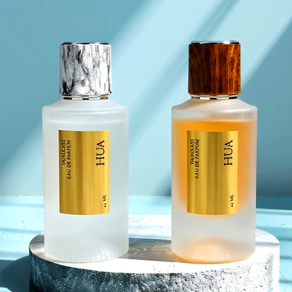 HUA0159 perfume bottle, cylindrical frosted glass body with 30 ml or 50 ml liquid, cylindrical plastic cap with silver rings at both ends, water transfer printed logo, modern elegant design, ideal for gifting and daily use.