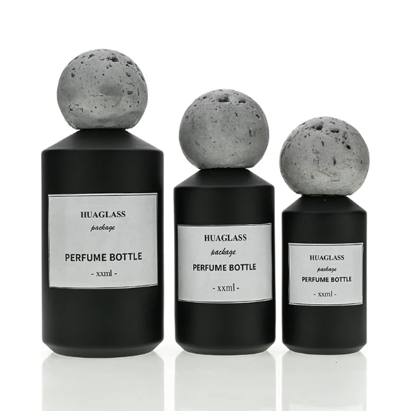 HUA0161 perfume bottle, cylindrical glass body with matte solid-color spray finish and 30 ml, 50 ml, or 100 ml liquid, spherical artificial stone cap, outer label with printed logo, modern elegant design, ideal for gifting and daily use.