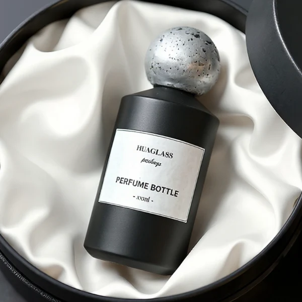 HUA0161 perfume bottle, cylindrical glass body with matte solid-color spray finish and 30 ml, 50 ml, or 100 ml liquid, spherical artificial stone cap, outer label with printed logo, modern elegant design, ideal for gifting and daily use.