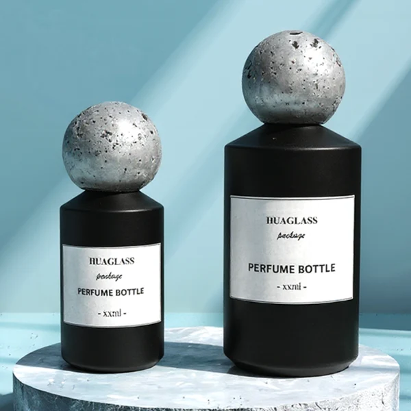 HUA0161 perfume bottle, cylindrical glass body with matte solid-color spray finish and 30 ml, 50 ml, or 100 ml liquid, spherical artificial stone cap, outer label with printed logo, modern elegant design, ideal for gifting and daily use.