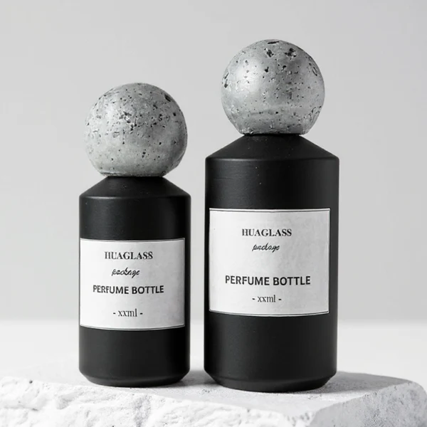 HUA0161 perfume bottle, cylindrical glass body with matte solid-color spray finish and 30 ml, 50 ml, or 100 ml liquid, spherical artificial stone cap, outer label with printed logo, modern elegant design, ideal for gifting and daily use.