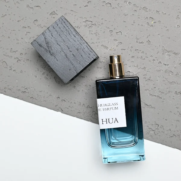 HUA0163 perfume bottle, rectangular gradient glass body with 30 ml, 50 ml, or 100 ml liquid, tall square wooden cap, outer label with printed logo, modern elegant design, ideal for gifting and daily use.