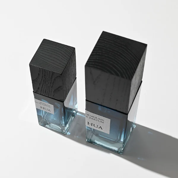 HUA0163 perfume bottle, rectangular gradient glass body with 30 ml, 50 ml, or 100 ml liquid, tall square wooden cap, outer label with printed logo, modern elegant design, ideal for gifting and daily use.