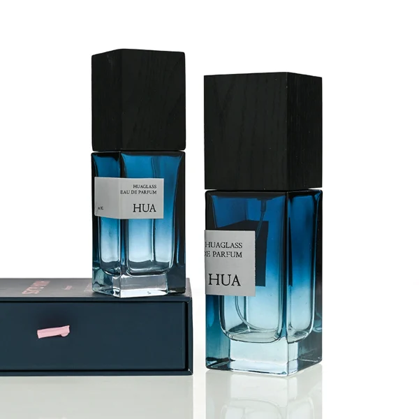 HUA0163 perfume bottle, rectangular gradient glass body with 30 ml, 50 ml, or 100 ml liquid, tall square wooden cap, outer label with printed logo, modern elegant design, ideal for gifting and daily use.