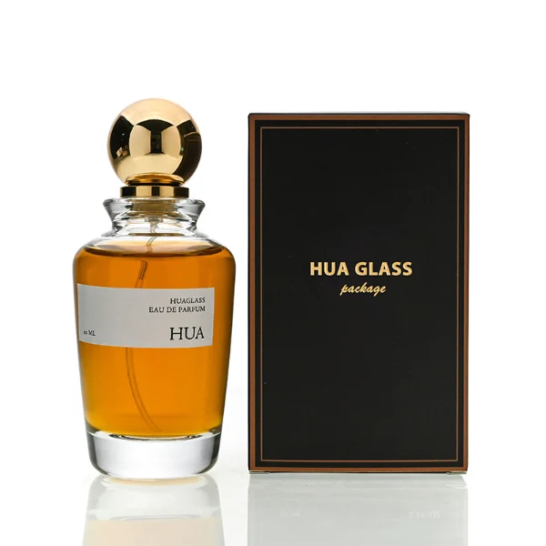 HUA0167 perfume bottle, kettle-shaped cylindrical transparent glass body with 50 ml or 100 ml liquid, spherical glossy plastic cap with gold neck, outer label with printed logo, modern elegant design, ideal for gifting and daily use.