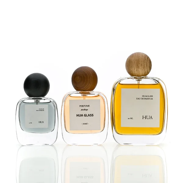 HUA0168 perfume bottle, rectangular transparent glass body with 30 ml, 50 ml, or 100 ml liquid, spherical wooden cap, outer label with printed logo, modern natural elegant design, ideal for gifting and daily use.