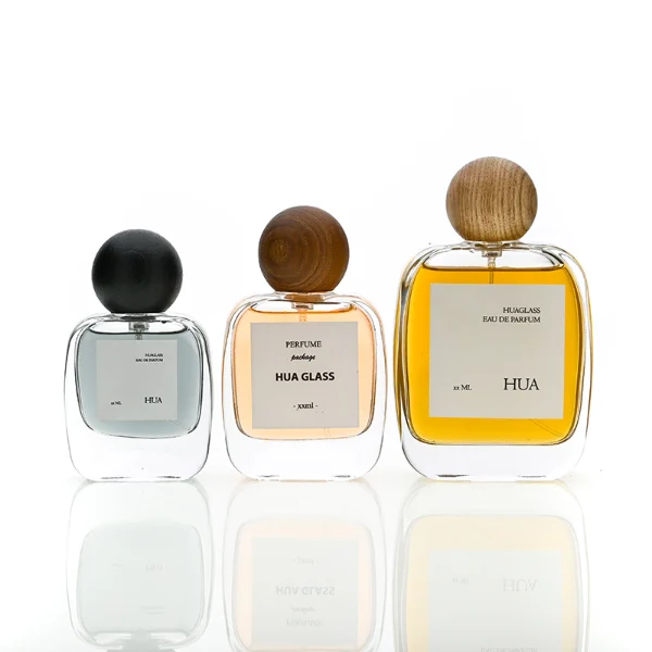 HUA0168 perfume bottle, rectangular transparent glass body with 30 ml, 50 ml, or 100 ml liquid, spherical wooden cap, outer label with printed logo, modern natural elegant design, ideal for gifting and daily use.
