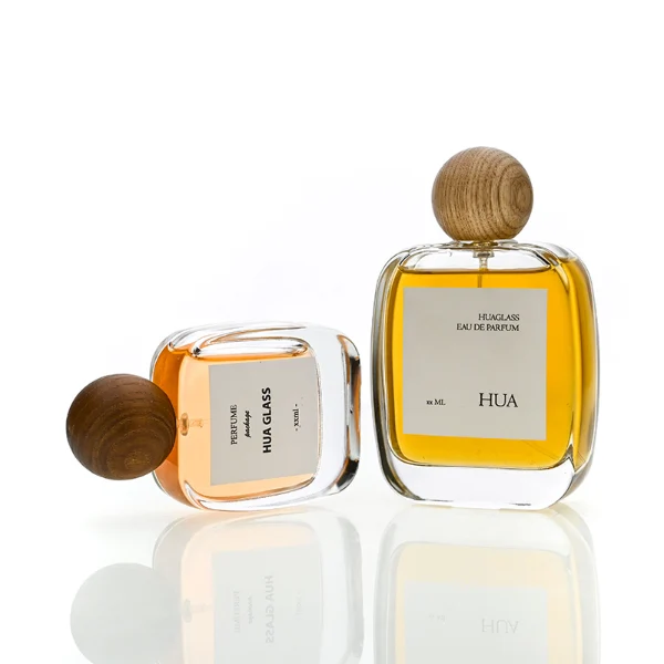 HUA0168 perfume bottle, rectangular transparent glass body with 30 ml, 50 ml, or 100 ml liquid, spherical wooden cap, outer label with printed logo, modern natural elegant design, ideal for gifting and daily use.