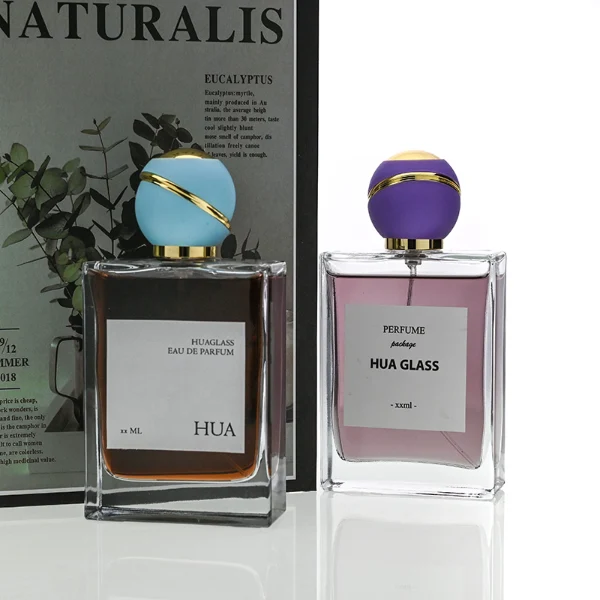 HUA0171 perfume bottle, rectangular transparent glass body with 30 ml, 50 ml, or 100 ml liquid, spherical plastic cap with diagonal gold stripe detailing and gold neck ring, outer label with printed logo, modern elegant design, ideal for gifting and daily use.